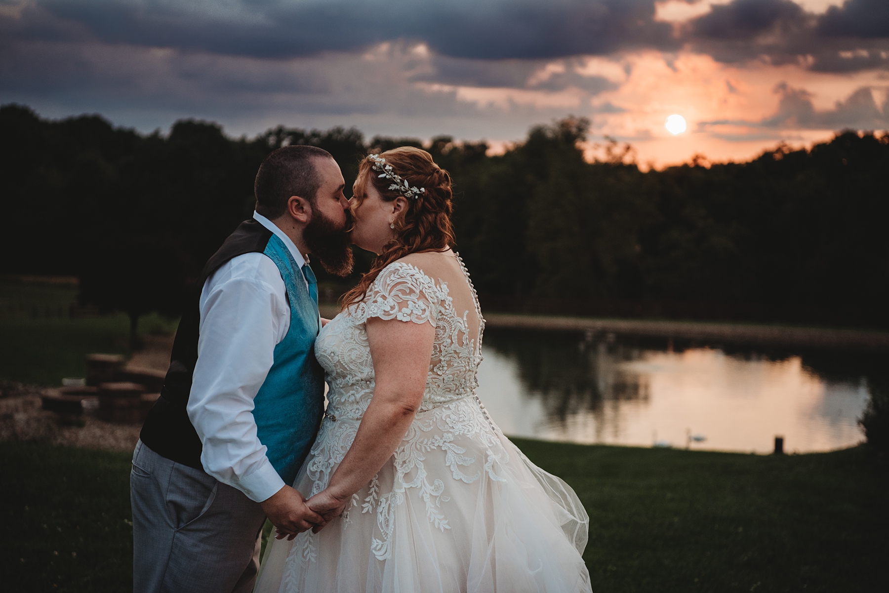 couple kiss at sunset by the pond at Peacock Ridge wedding
