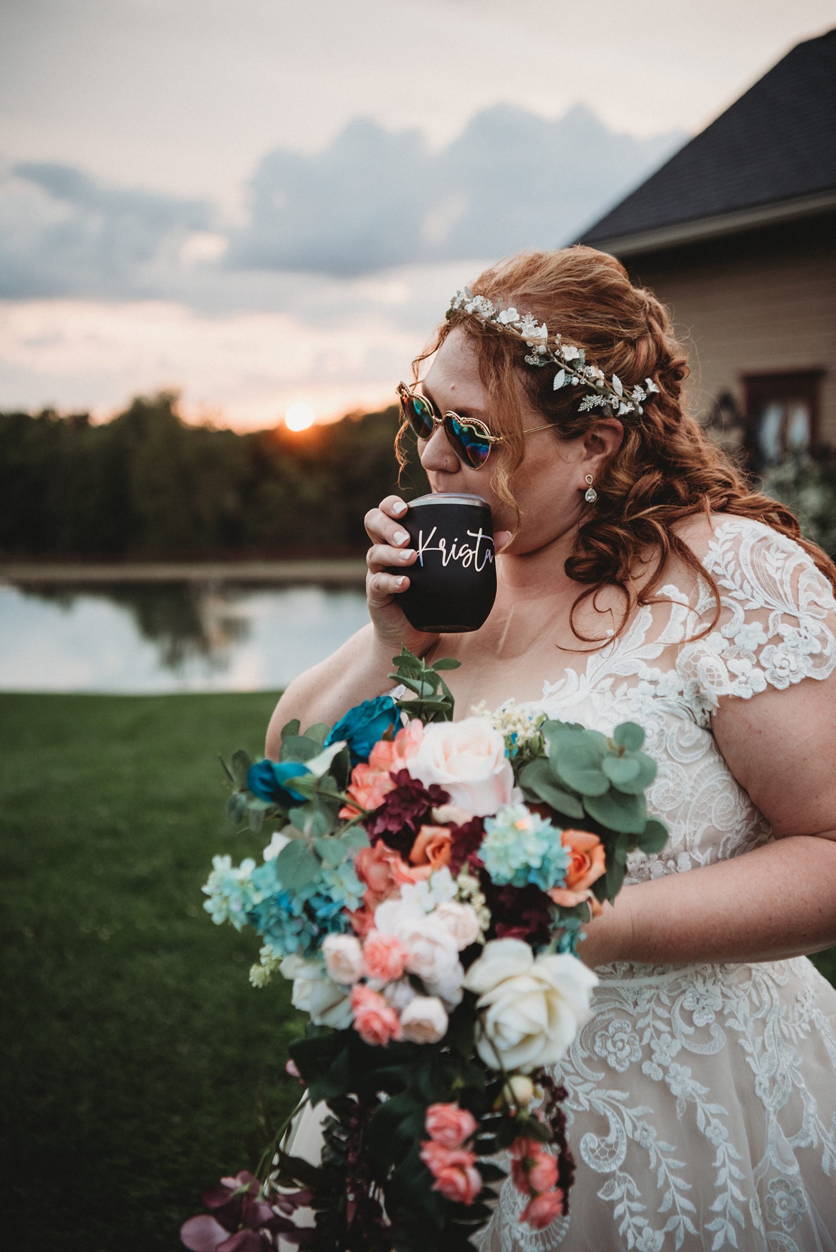 bride holds gorgeous wedding bouquet and sip a drink by the pond 