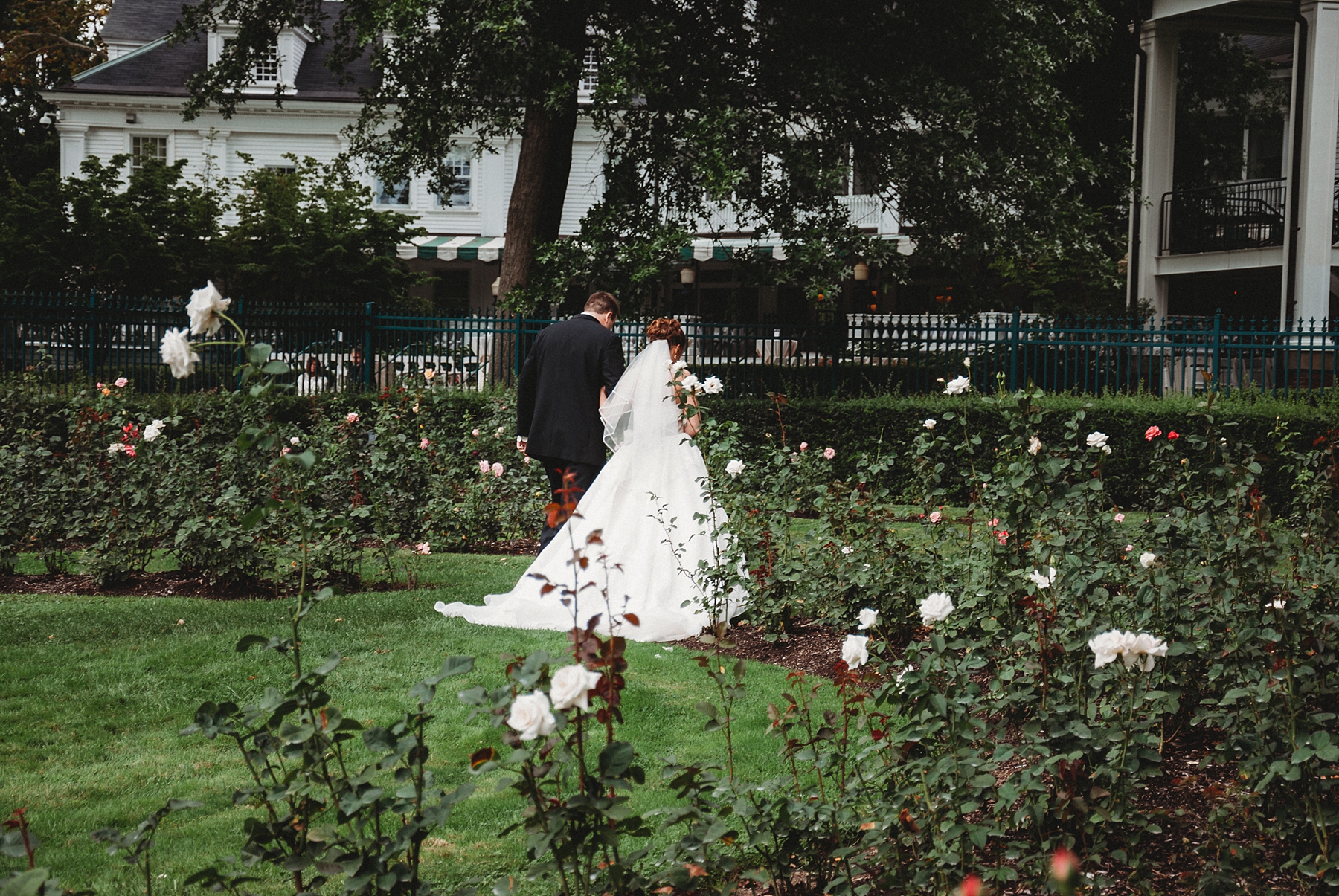 newlyweds walk through the gardens of Mooreland Mansion