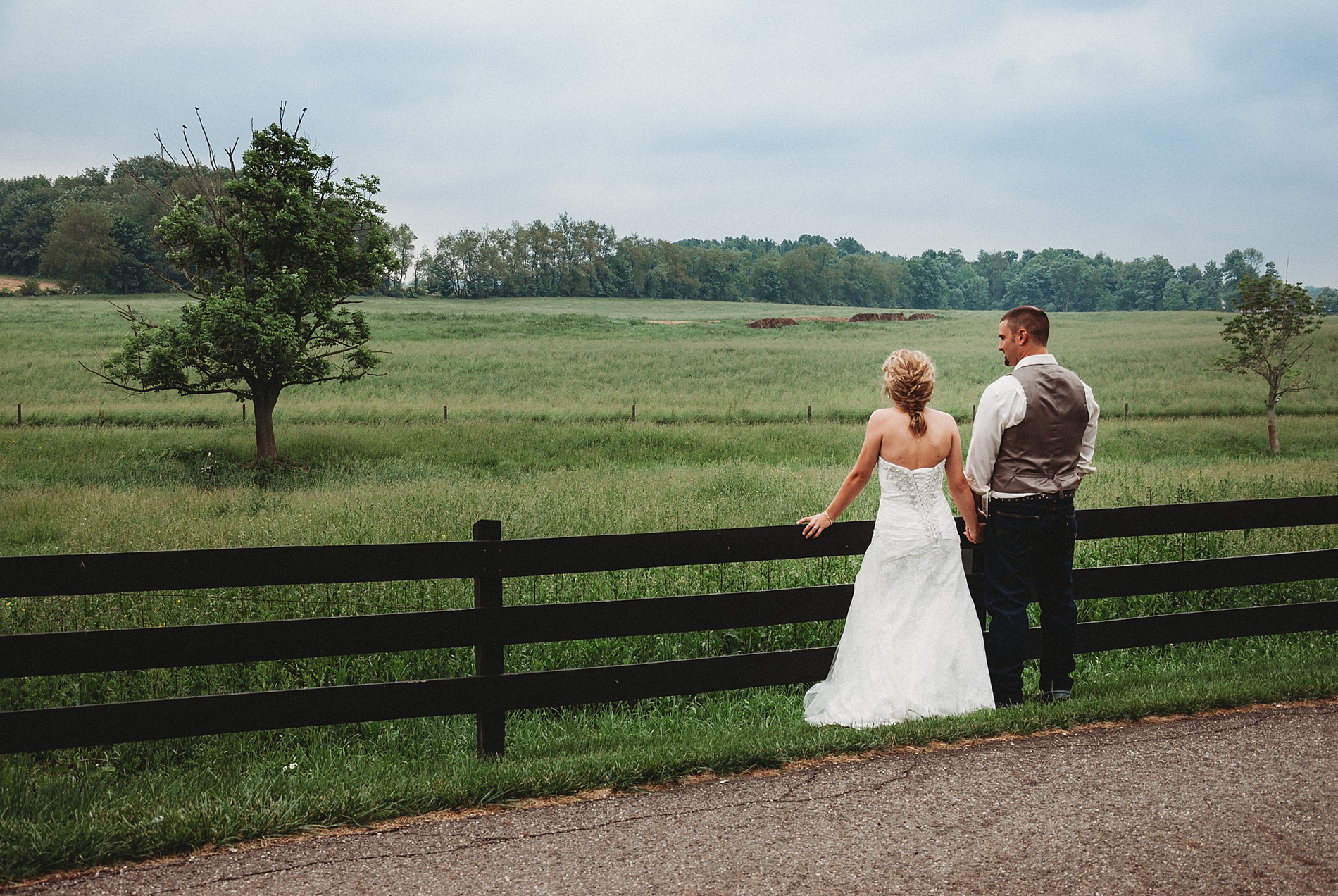 bride and groom looking out at the countryside of Brookside farms in Ohio