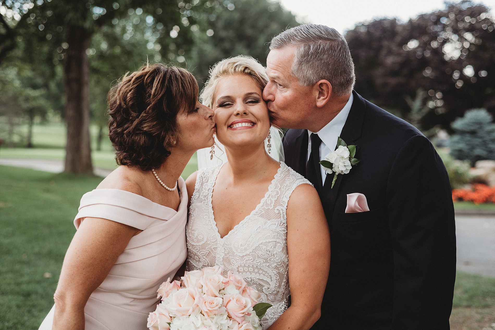 bride's parents kiss her cheek at Mapleside Farms one of The Top 14 Barn Wedding Venues in Ohio