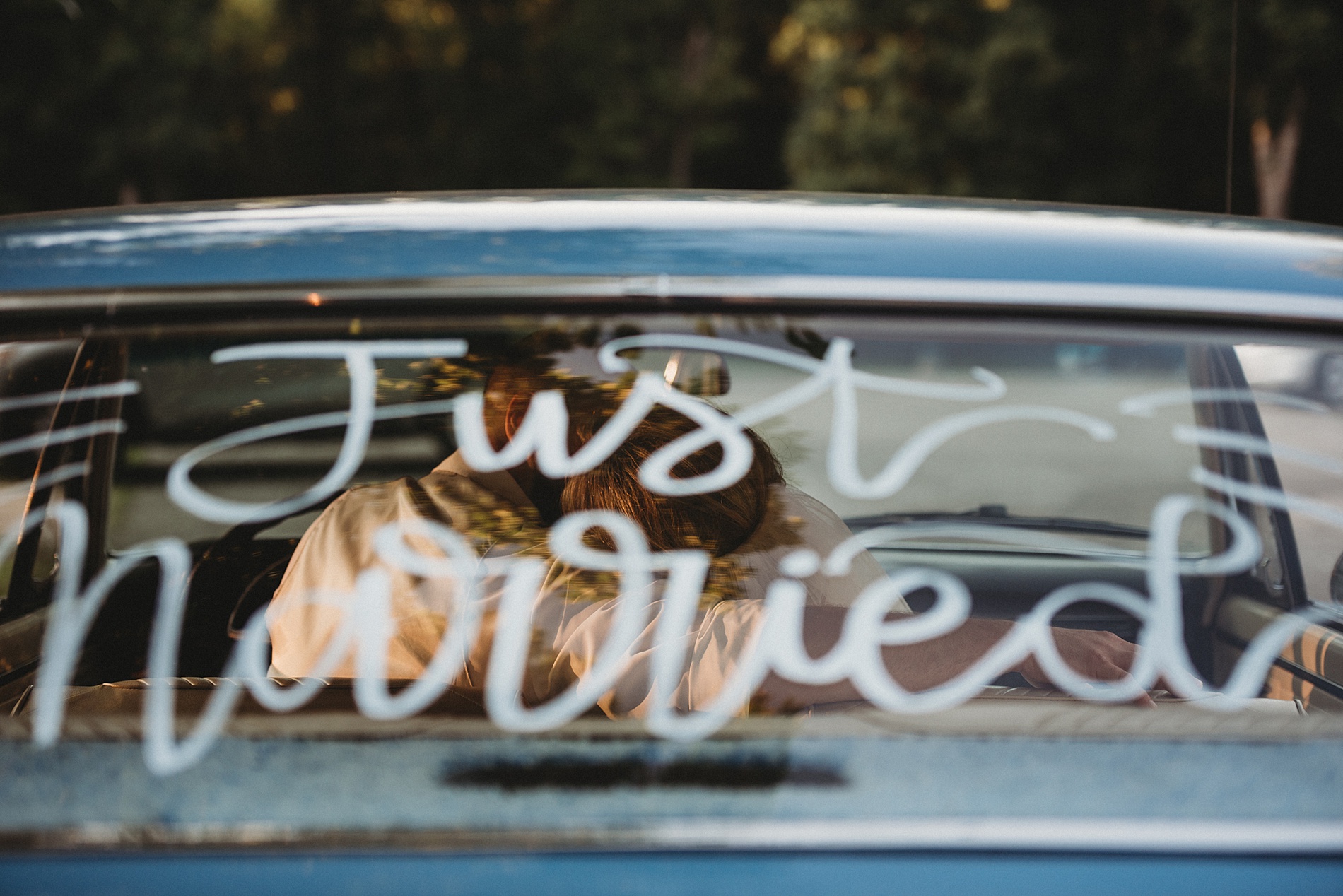 newlyweds in car with just married on the windshield 