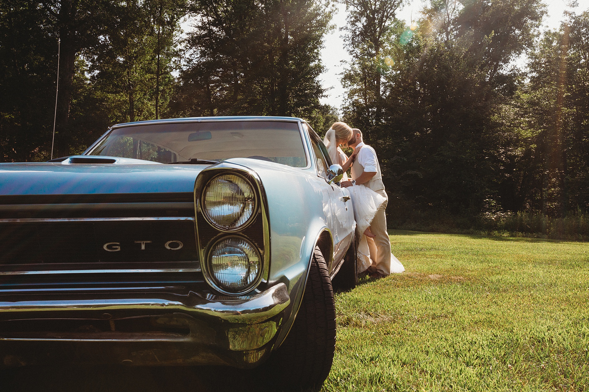 bride and groom kiss up against getaway car at the Gish Barn one of The Top 14 Barn Wedding Venues in Ohio