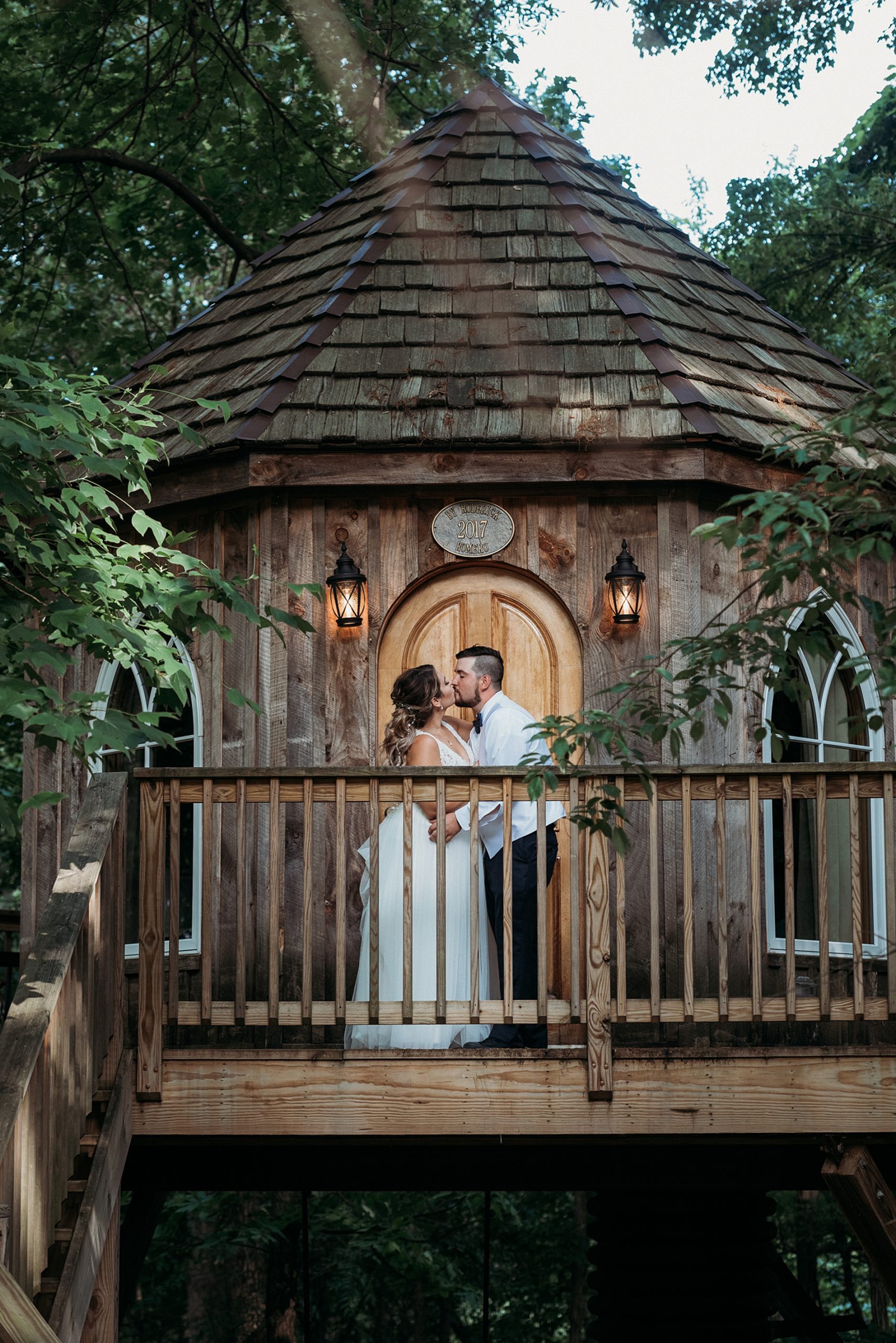 Bride and groom stand on balcony of treehouse at the Grand Barn at the Mohicans one of The Top 14 Barn Wedding Venues in Ohio