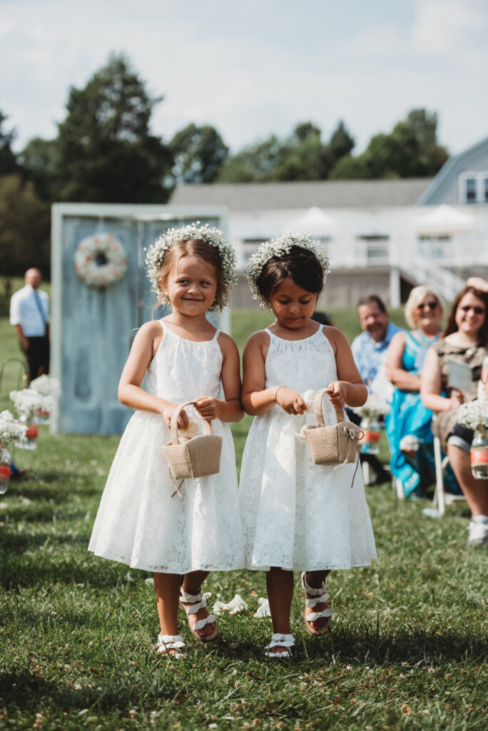 flower girls walking down the aisle at their Varian Orchards wedding